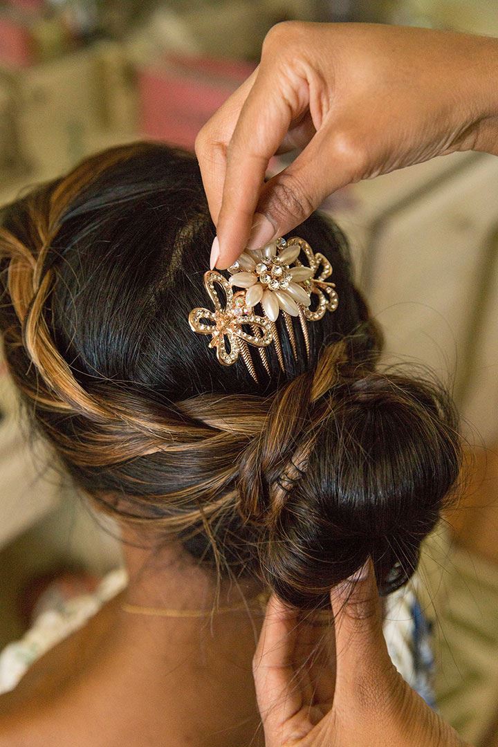 Putting a floral barrette into brides hair