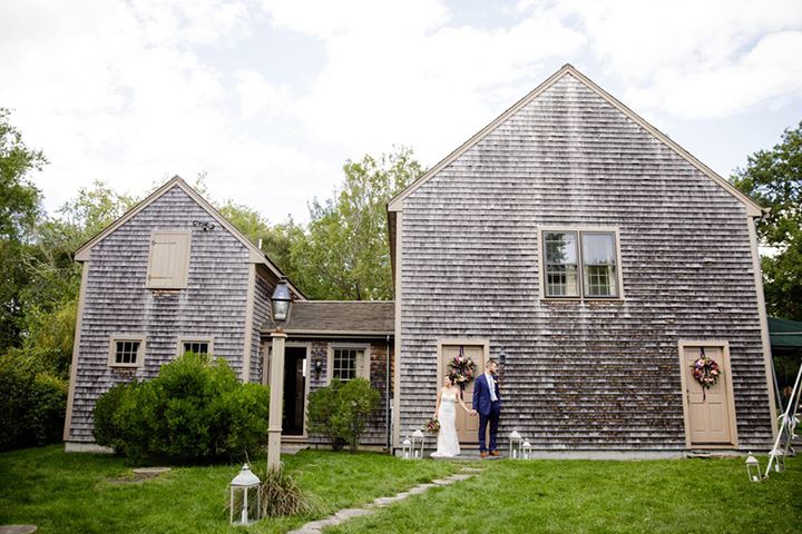 bride and groom standing in front of old house