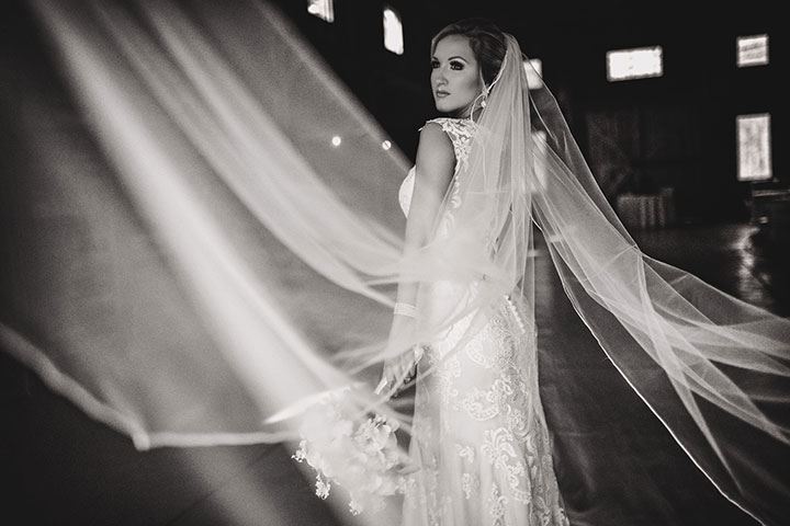 black and white photo of bride wearing a dramatic veil