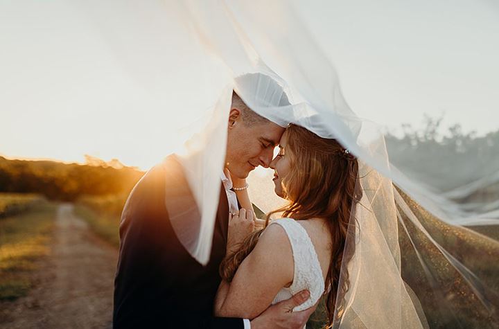bride and groom hugging each other under a veil Desktop Image