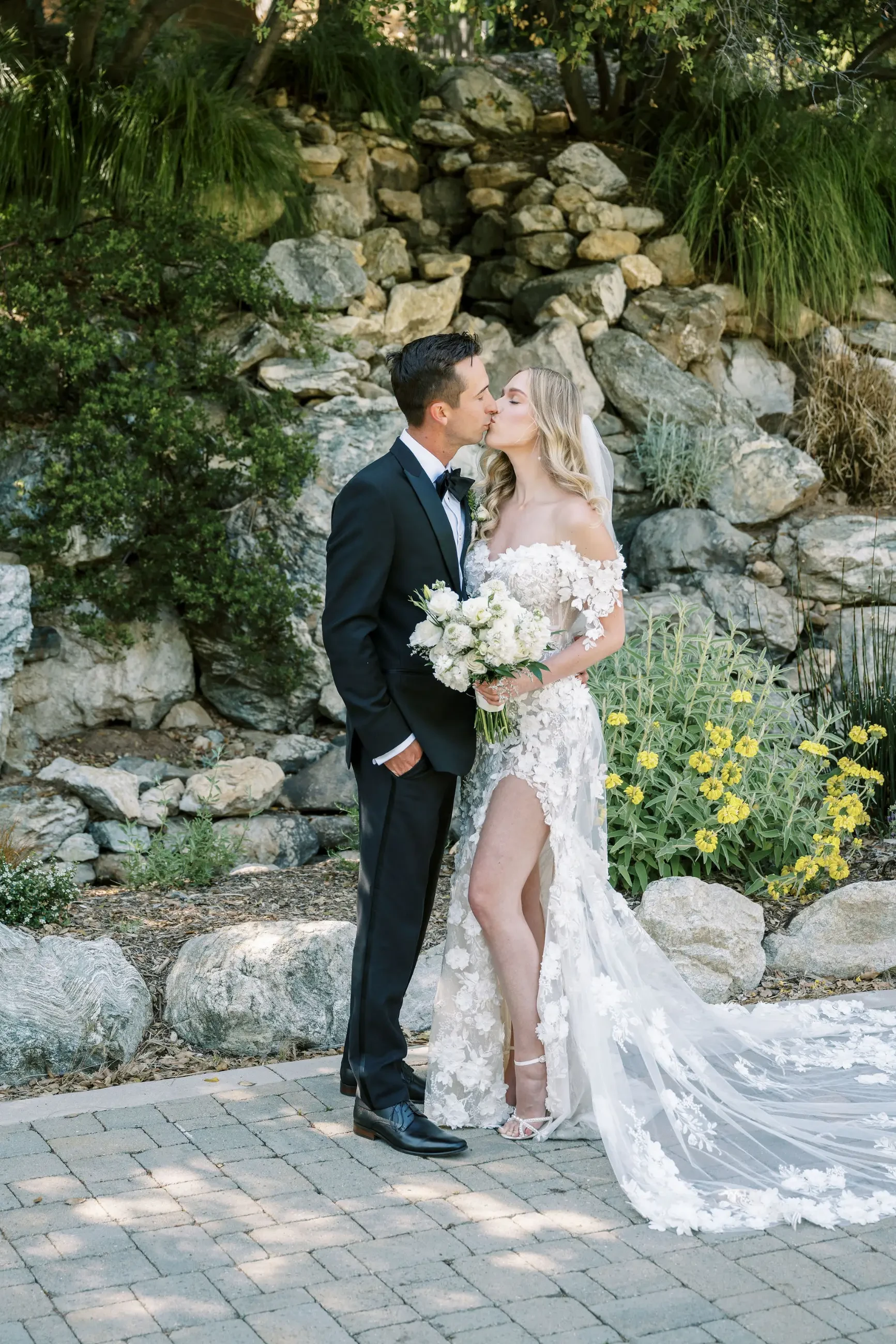 image shows bride kissing her groom on their wedding day
