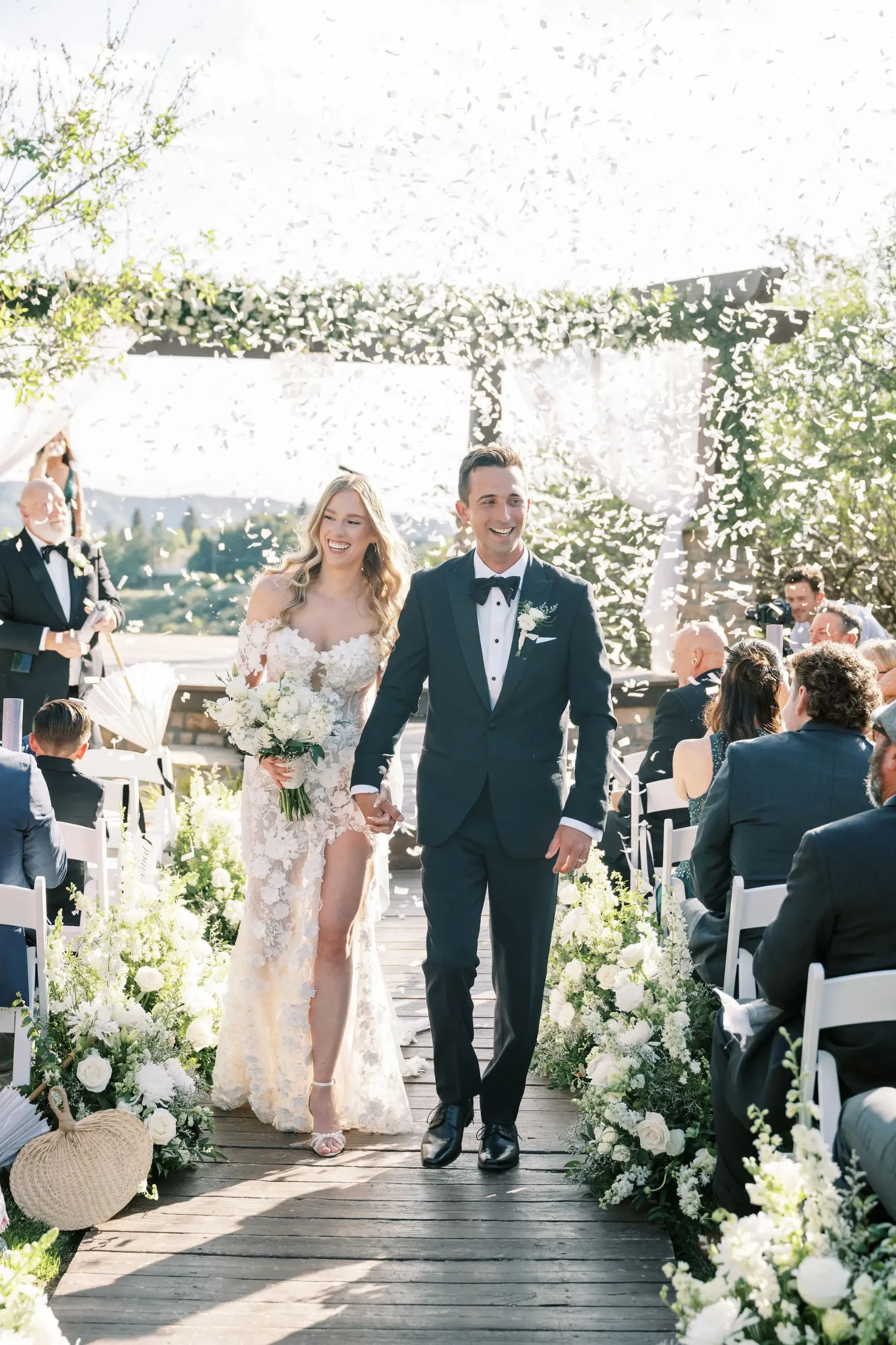 image shows bride and husband smiling walking back down the aisle after getting married