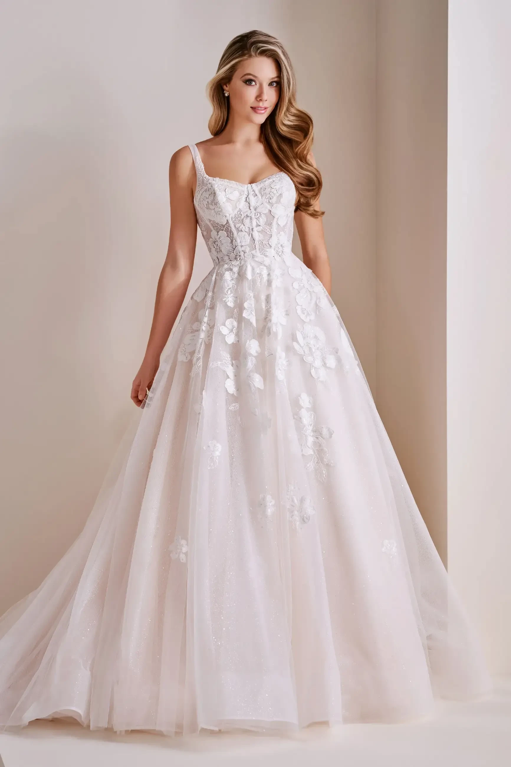 Model is wearing a glitter tulle A-line wedding dress with lace appliqué, a sweetheart neckline, and a fitted corset bodice.