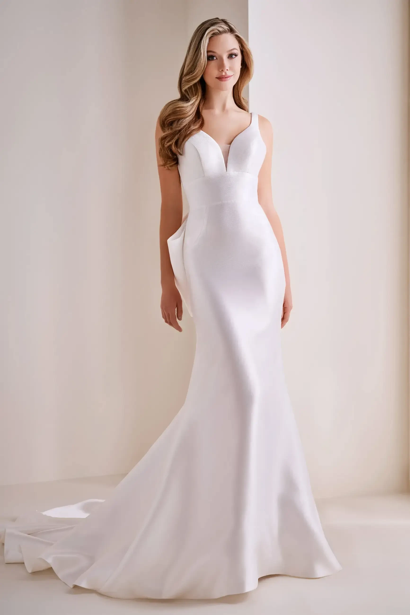 Model is wearing a Mikado mermaid wedding dress in diamond white featuring a sweetheart neckline and detachable back bow.