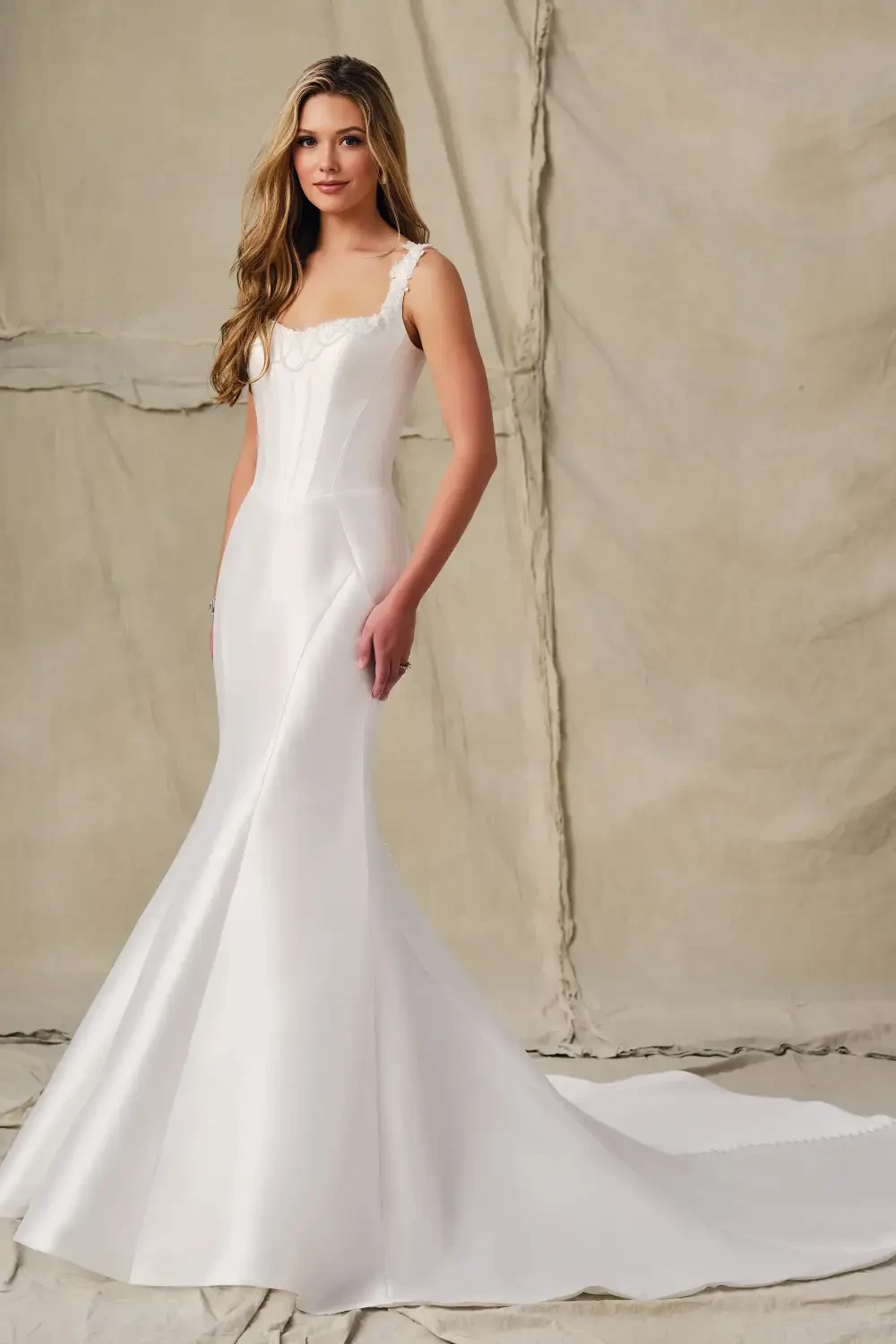 model is wearing a sleeveless bridal gown with a sweetheart neckline