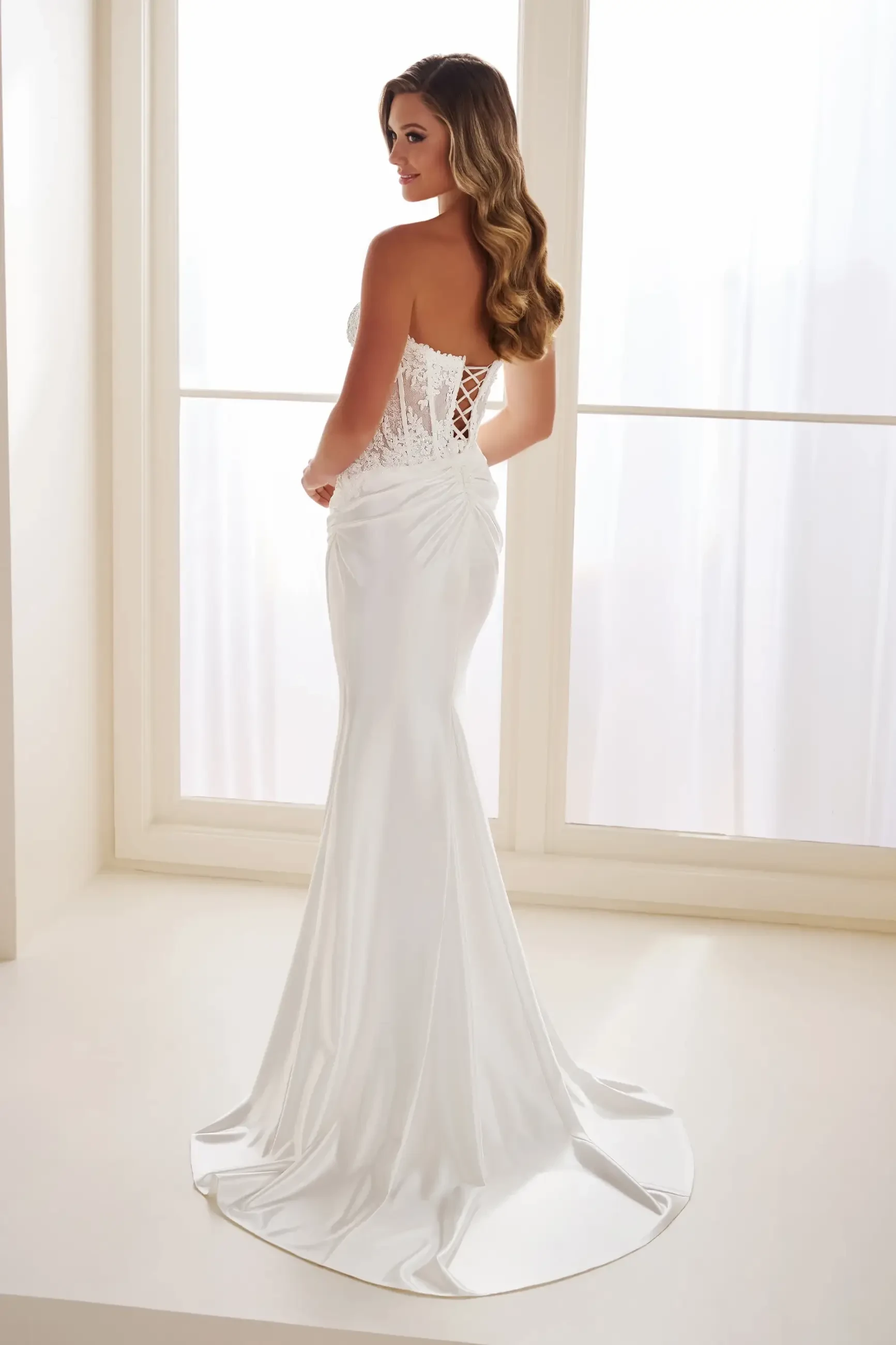 Model is wearing a mermaid wedding dress made of stretch satin and sequins