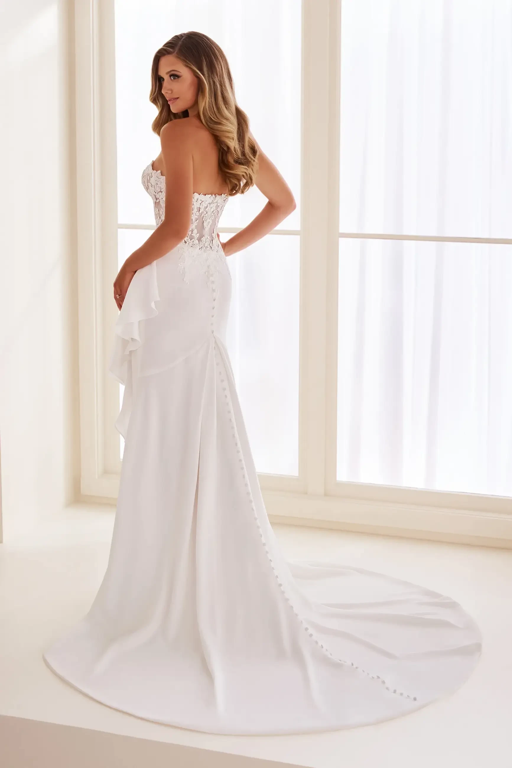 Model is wearing a fit and flare wedding dress made of sleek crepe
