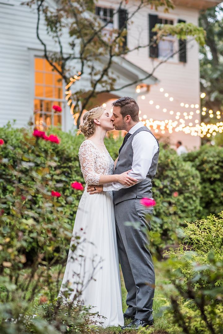 bride and groom kissing in a garden