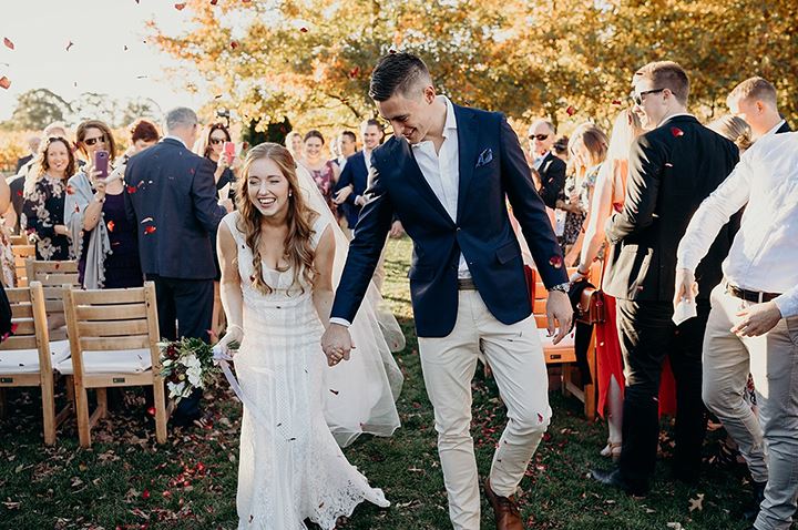 bride and groom holding hands as they leave their ceremony