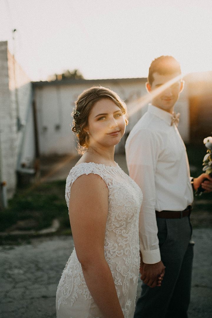 Bride and groom holding hands at sunset