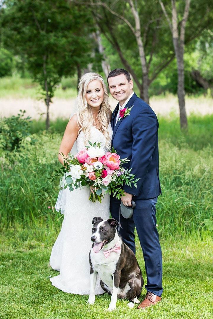 Bride and groom smiling with their dog